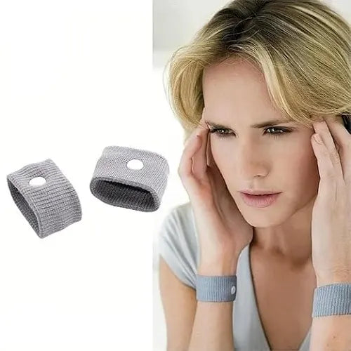 A woman experiencing severe nausea and a headache rubbing her temples, displayed alongside a pack of 2 grey drug-free anti-nausea wristbands designed to alleviate travel sickness and vertigo symptoms naturally.