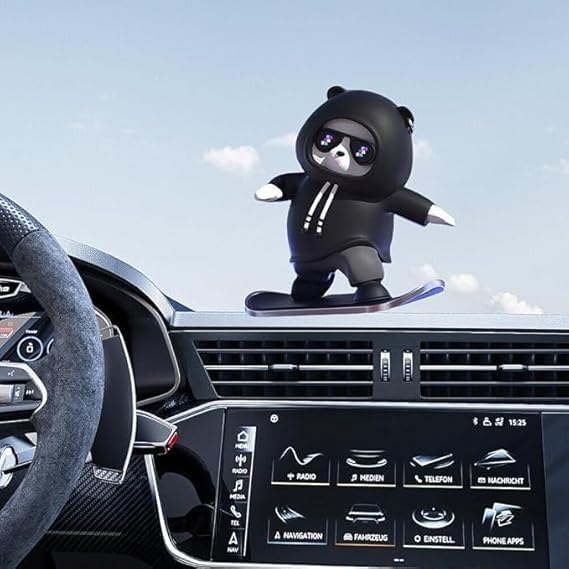 Car dashboard with a black bear-shaped car air freshener and a clear blue sky.