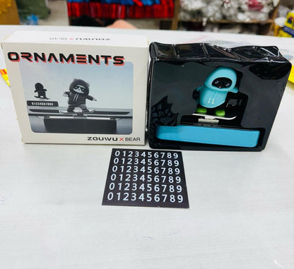 Black and blue figurine with a box labeled 'Ornaments' and a number card on a white surface.