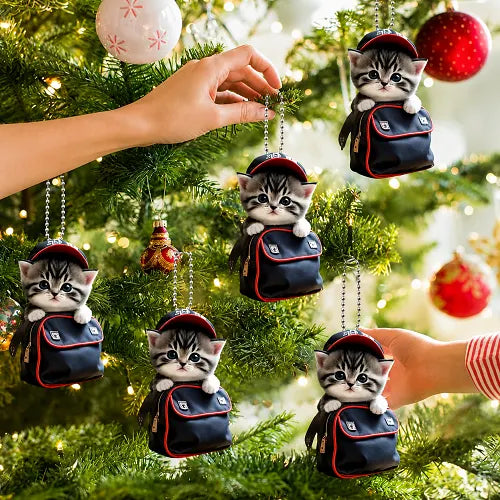 Multiple cute kitten in a backpack car hanging pendants being used as festive holiday decorations, hanging beautifully on a lit Christmas tree.