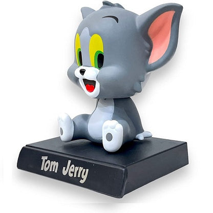 Angled profile view of the smiling Tom cartoon nodding head toy, a decorative interior accessory for cars.