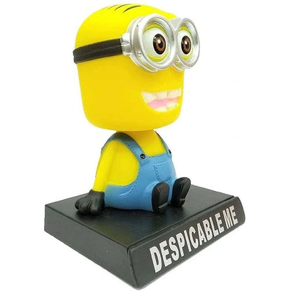Angled front view of a cute Minion shaking head toy, a decorative interior accessory for car dashboards.