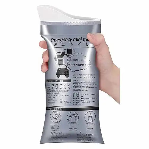 A hand holding the Gokyo 700CC disposable urine and vomit bag, displaying the silver emergency mini toilet pouch designed for road trips and travel emergencies.