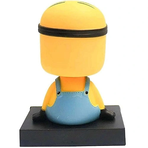 Back view of the yellow Minion car dashboard nodding toy, showing the back of the figure's head and blue overalls.