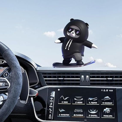 Car dashboard with a black bear-shaped car air freshener and a clear blue sky.
