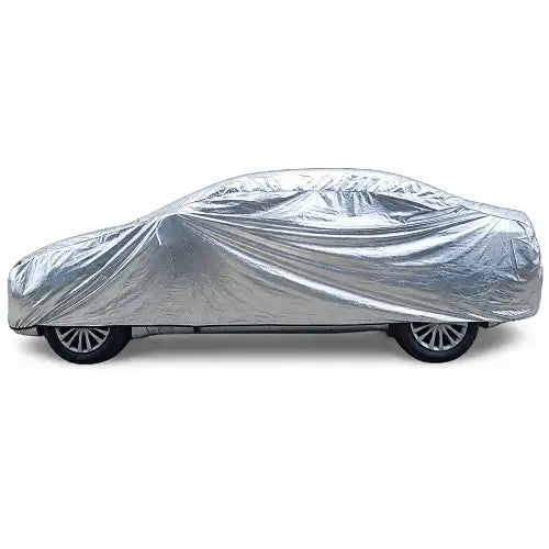Side profile view of a premium silver reflective full exterior car cover tightly fitted over a sedan on a clean white background, designed for complete all-weather body protection.