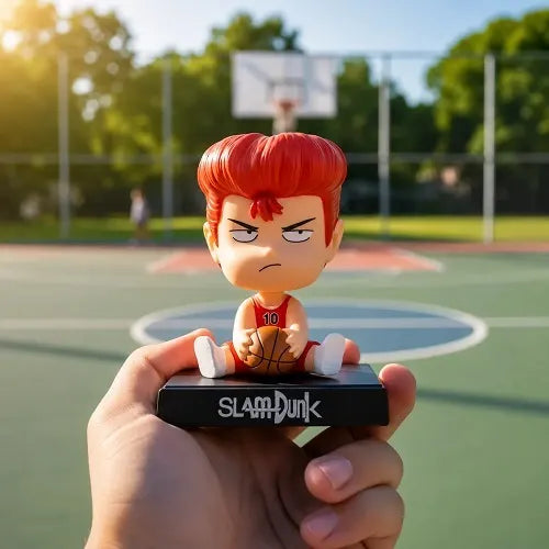 A handheld view of the Slam Dunk basketball anime collectible figure featuring Hanamichi Sakuragi, photographed outdoors against a sunny basketball court background to highlight its thematic design.