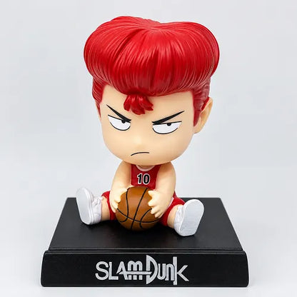 Front view of a chibi-style Slam Dunk car dashboard figure featuring Hanamichi Sakuragi holding a basketball, sitting on a sleek black base with the official anime logo.
