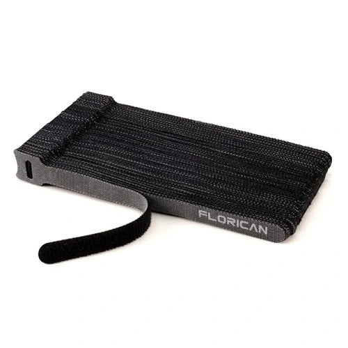 A neat, tear-off stack of black Florican reusable fastening cable ties, showing a single hook and loop strap easily peeling away from the pack for quick use.