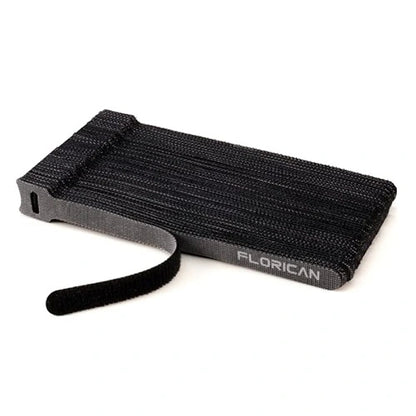 A neat, tear-off stack of black Florican reusable fastening cable ties, showing a single hook and loop strap easily peeling away from the pack for quick use.