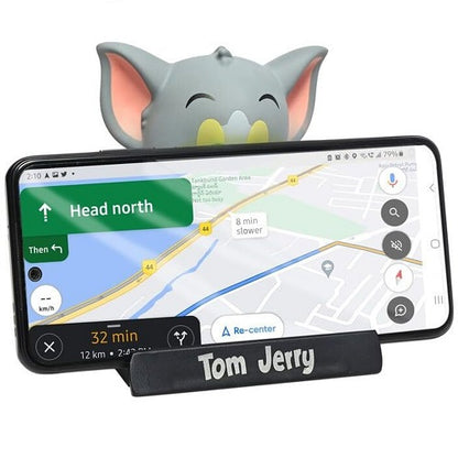 Tom bobblehead car dashboard accessory functioning as a mobile phone holder, securing a smartphone horizontally for GPS navigation