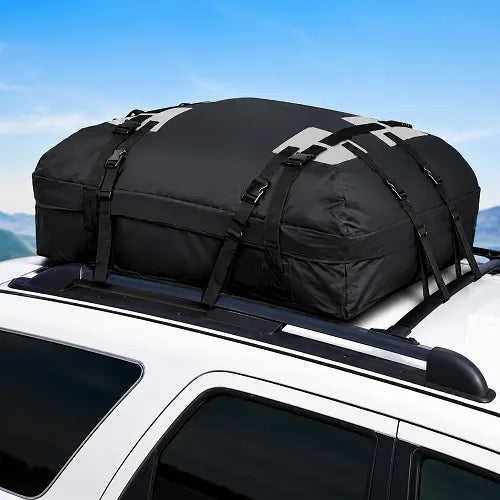 The Velura rooftop cargo carrier bag securely installed on the roof rack crossbars of a white SUV, illustrating a perfect fit for road trips and family travel under a clear blue sky.