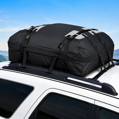 The Velura rooftop cargo carrier bag securely installed on the roof rack crossbars of a white SUV, illustrating a perfect fit for road trips and family travel under a clear blue sky.